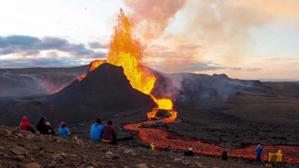 Vulkanausbruch in Island mit fließender Lava und Menschen in sicherer Entfernung