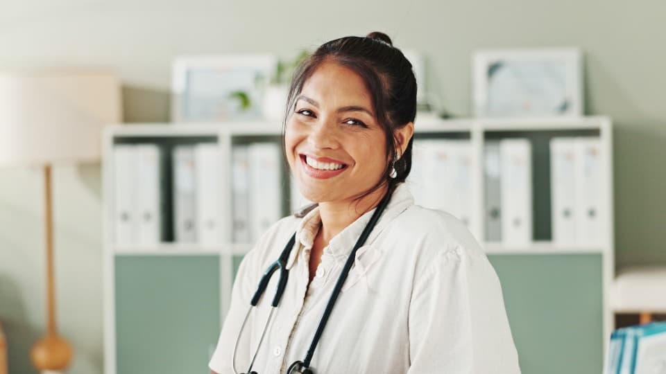 Mexican doctor smiling at the camera as a symbol of Mexico’s healthcare system.