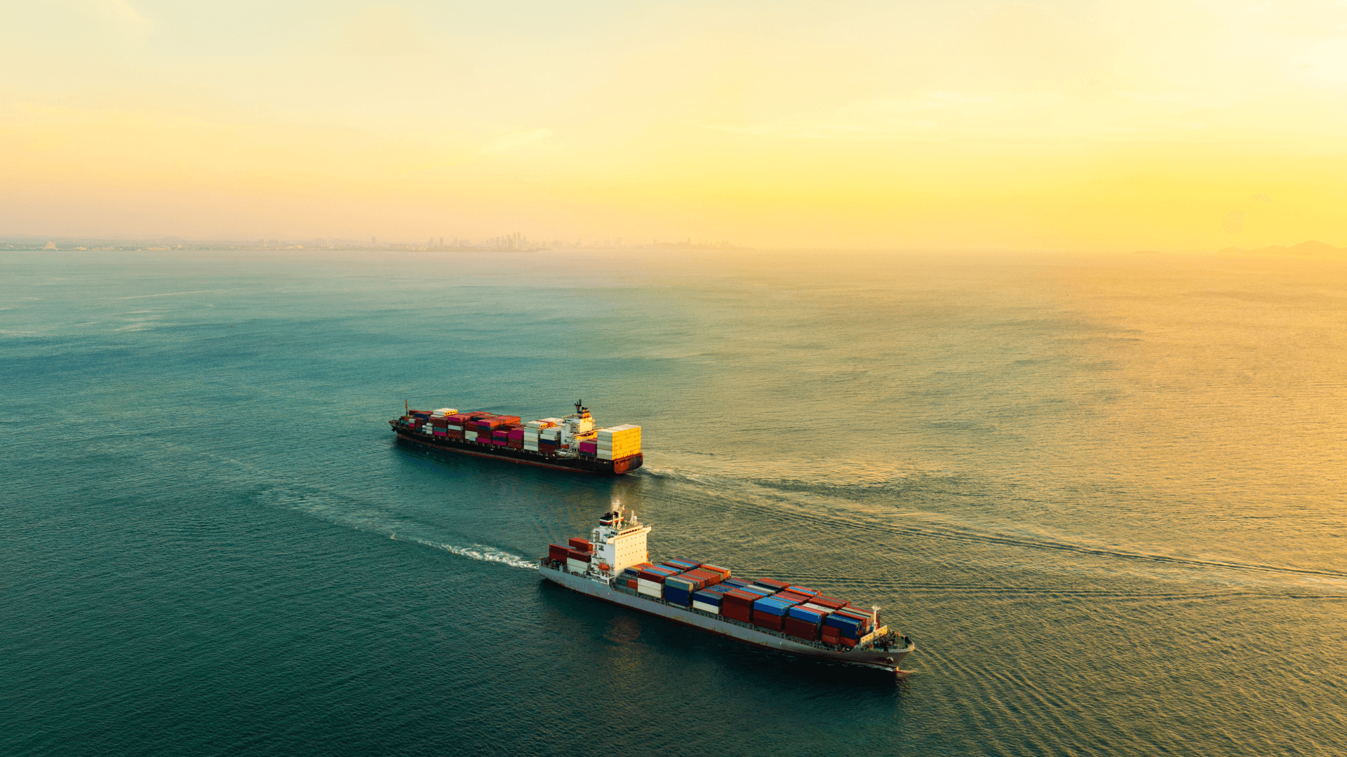 Beladenes Containerschiff einer Reederei am Kai im großen Hafen mit Kranen bei Sonnenuntergang.